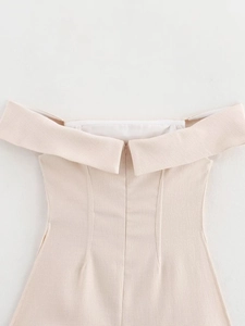 Detail of hidden back zipper and folded off-shoulder neckline on a woven textured dress
