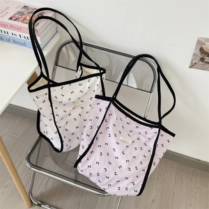 Dettaglio di borse tote in tela con stampe a fiocco nero su tessuto bianco e viola