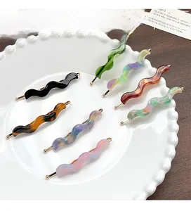 Macro detail of acetate wavy hairpins in various colors displayed on a white plate