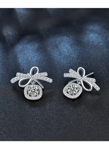 Macro detail of silver bow earrings with micro-pave zircons and round main stone