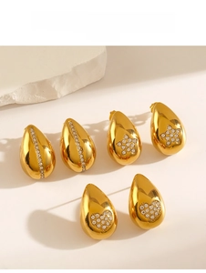 Détails de boucles d'oreilles dorées en goutte avec étoiles, cœurs et zircons sur pierre