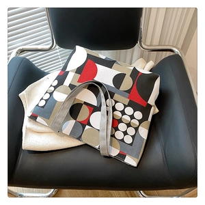 Detail shot of large canvas tote bag with geometric prints on a leather chair