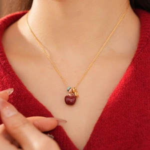 Dettaglio di una collana con ciondolo a mela placcata oro 18k con zirconi su una modella