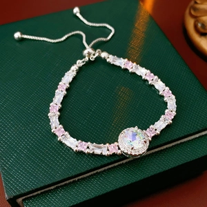 Detail of adjustable silver bracelet with pink and white cubic zirconia on green jewelry box