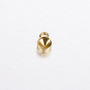 Close-up of polished gold-finished round stainless steel pendant tray blank with ring