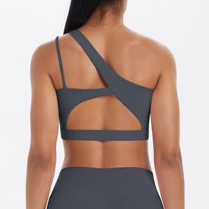 Detail view of charcoal grey sports bra featuring asymmetric crossover straps and open back