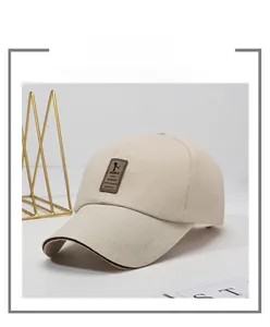 Detail of beige cotton baseball cap featuring a premium brown leather brand patch on front