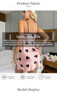 Détail du tissu en soie rose avec motif cœur et instructions de lavage pour la nuisette