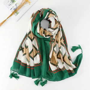 Detailed view of dark green ethnic printed scarf with tassels and geometric patterns