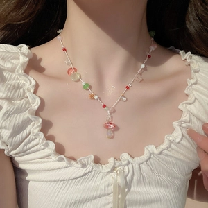 Detail shot of a sweet baroque pearl necklace with colorful beads and a mushroom pendant