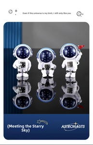 Tre figurine di astronauti in resina con caschi galassia su una superficie riflettente