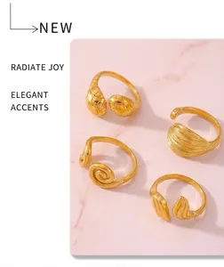 Close-up of four gold-plated 18k rings featuring textured patterns and open designs