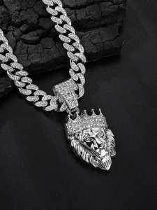 Close-up of silver Cuban chain necklace with a crown lion head pendant and clear stones