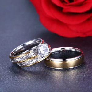 Macro shot of titanium couple rings with zircon stone and frosted two-tone metal texture