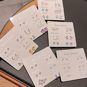 Set of 6 pairs of minimalist silver stud earrings with heart and flower designs on card