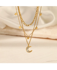 Detail of a triple-layered gold necklace with small stars and a mother-of-pearl crescent moon