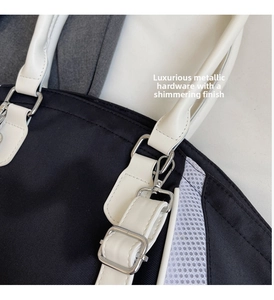 Close-up of durable nylon texture with silver metal buckles and leather bag handle
