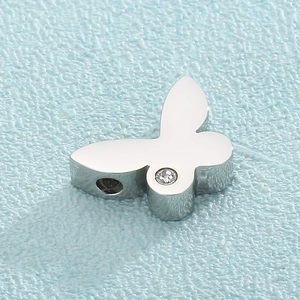 Macro shot of silver butterfly charm with sparkling diamond accent and polished steel finish