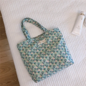 Gros plan détaillé d'un sac cabas en coton fleuri avec une étiquette tissée sur le devant