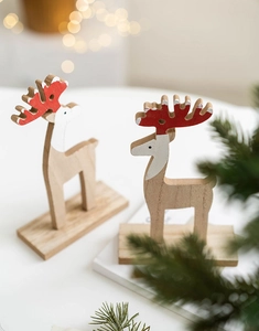 Detail of wooden reindeer tabletop ornaments with red antlers for Christmas decor