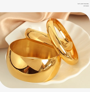Three-piece gold titanium steel bangle set with mirror polish on champagne silk