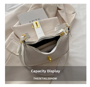 Detail view of woven leather shoulder bag showing interior capacity and golden twist lock