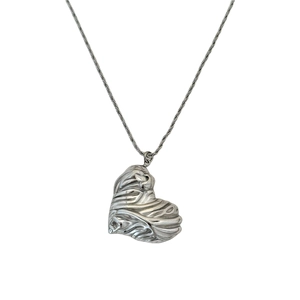 Macro view of vintage heart pendant featuring 18k gold plated wave texture surface