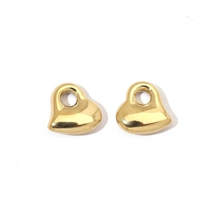 Macro view of gold-plated heart-shaped metal charms with polished mirror finish for DIY