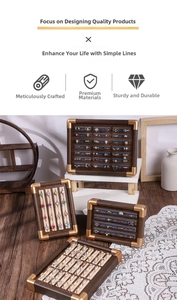 Detail of walnut wood jewelry tray with gold metal corners and velvet ring slots