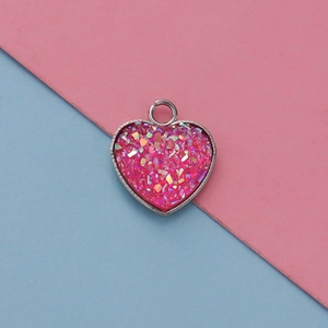 Detailed macro view of heart-shaped pendant with pink glitter fill and silver metal frame