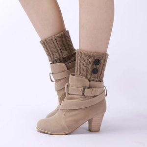 Close-up of beige suede ankle boots with khaki cable knit buttoned leg warmers and cuffs