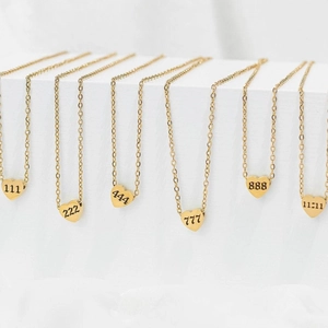 Golden heart pendant necklaces with angel numbers 111 to 11:11 on a white background