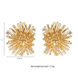 Detail view of fireworks-inspired gold earrings with dimensions 2.8cm and 2.4cm