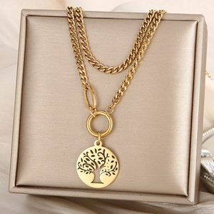 Close-up of golden Tree of Life pendant on a layered Cuban link chain jewelry box