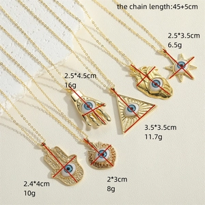 Detailed view of various gold Evil Eye pendants including Hamsa and heart shapes