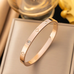 Fashion rose gold stainless steel bangle featuring hollow clover pattern and crystal stones