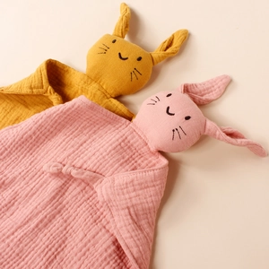 Detail of pink and yellow cotton muslin baby pacifier towels in cute rabbit doll shapes