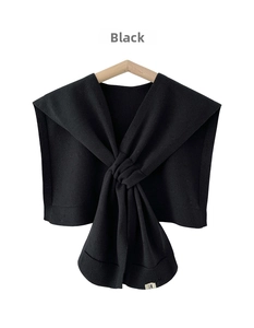 Close-up of black knitted shawl featuring fine ribbed edges and elegant crossover knot design