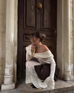 Close-up of cream off-shoulder crochet dress showing intricate knit texture and pattern