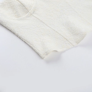Detailaufnahme weißer floraler Spitze und feiner Stickereitextur an einem Korsettoberteil