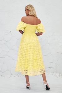 Detail view of the elastic shirred back and layered tier hem on this yellow summer dress