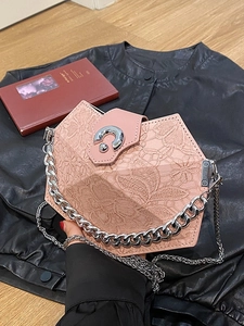 Pink hexagonal handbag with lace texture, silver chain strap, and minimalist swivel lock