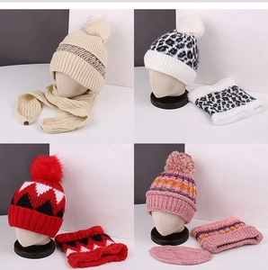 Detail view of winter knitted hat and scarf sets in four patterns with faux fur pom-poms