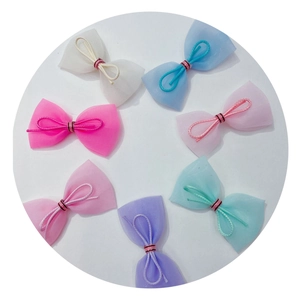 Assorted mesh bow hair accessories in seven colors for dolls or pets on white background