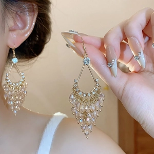 Gros plan de boucles d'oreilles dorées avec perles de verre en cristal sur un mannequin
