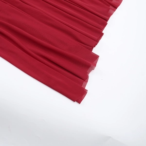 Détail du tissu en maille multicouche bordeaux sur une robe de soirée élégante