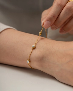 Detail of 18K gold plated stainless steel bracelet with three round cubic zirconia stones