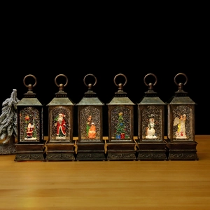 Detail of vintage bronze Christmas lanterns with glitter snow and holiday scenes