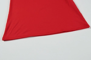 Detail shot of the red evening dress hem featuring precise double-needle stitching and fabric