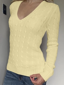 Gros plan du pull en maille jaune clair à col en V avec un motif de tricot torsadé classique